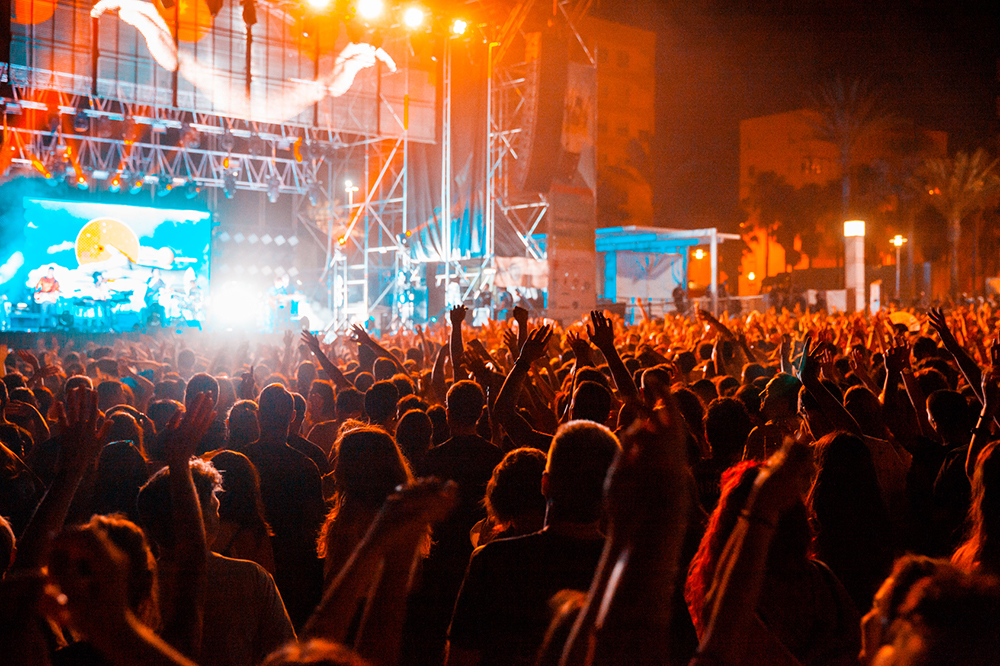 Large outdoor concert crowd with LED wall